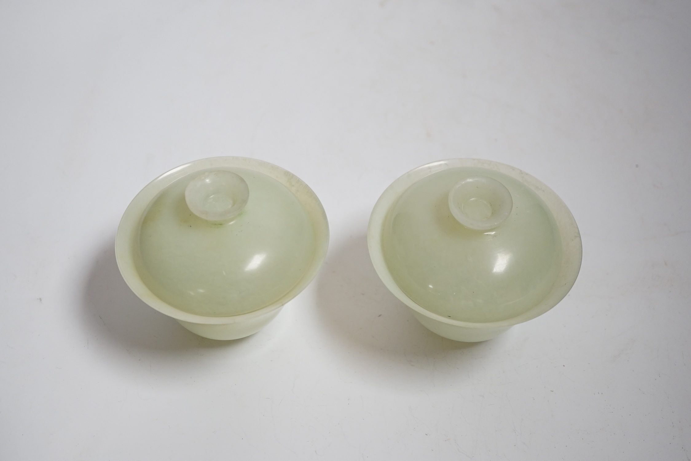 A pair of Chinese bowenite cups and covers, 10cm in diameter